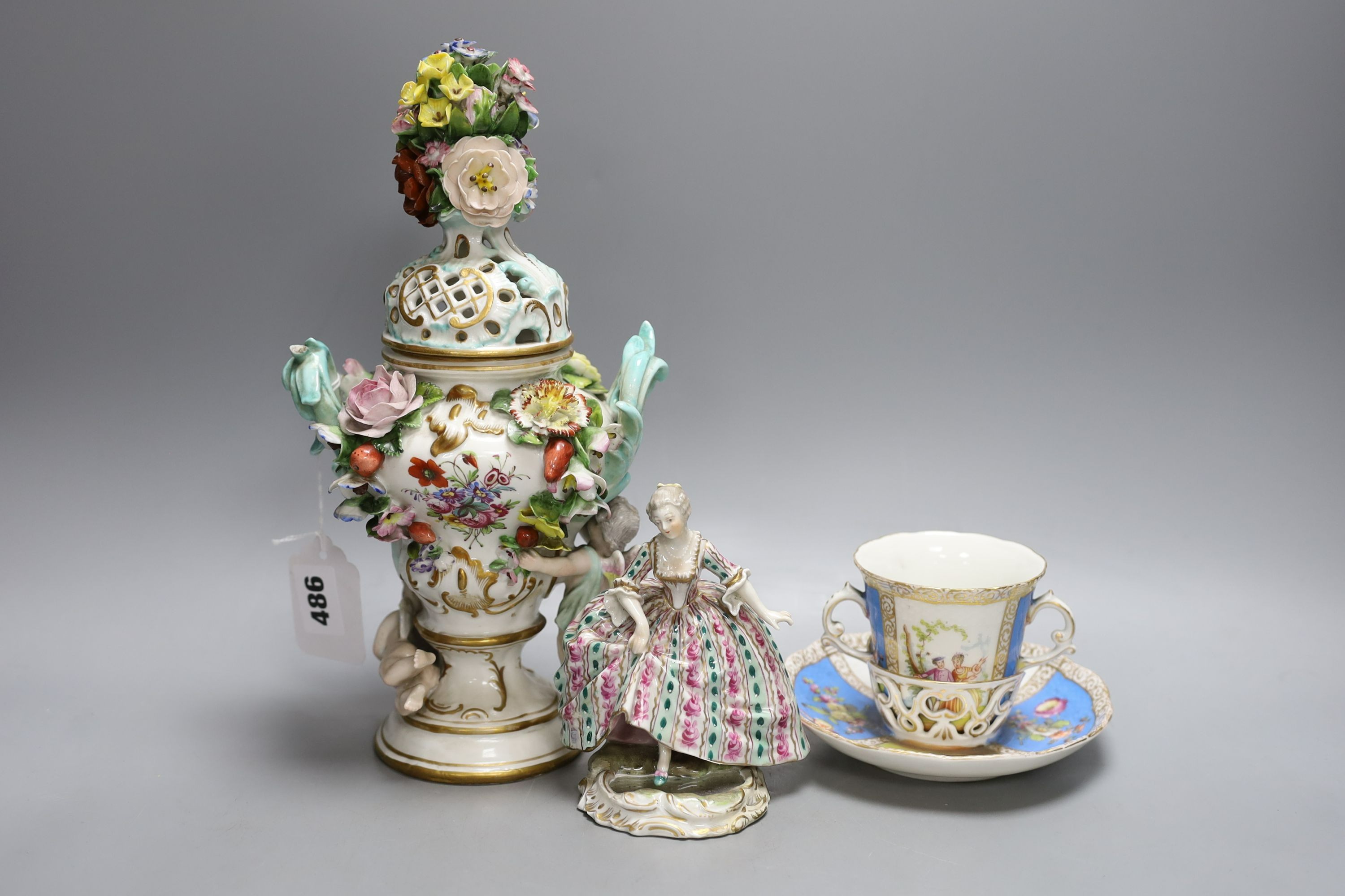 A Dresden floral encrusted pot pourri vase and cover, 29cm tall, a figure of a lady and a Dresden cup and trembleuse saucer